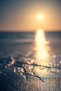 Ablaufend Wasser am Sylter Strand tief stehender Sonne über der Nordsee, Offenblende